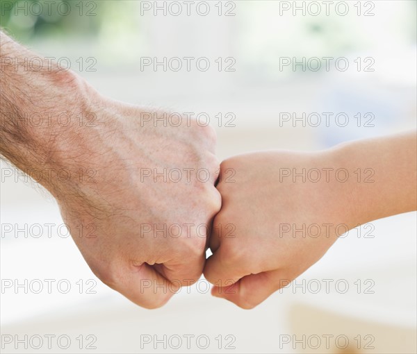 Close up of father's and son's (10-11 years) hands doing fist bump. 
Photo: Daniel Grill