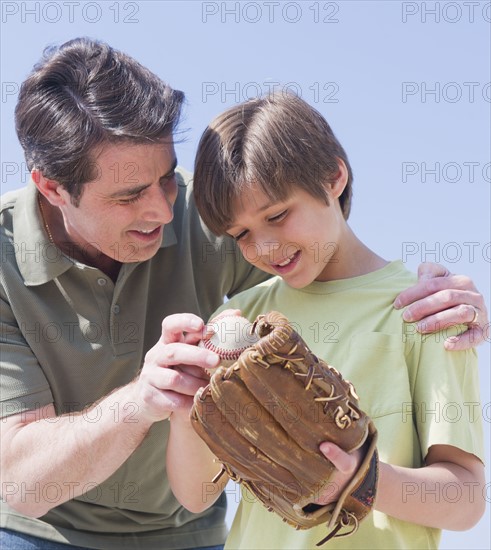 Father teaching son (10-11 years) how to play baseball.
Photo : Daniel Grill