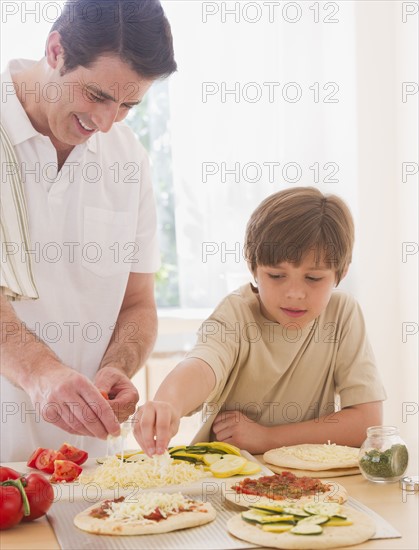 Father and son (10-11 years) preparing pizza. 
Photo : Daniel Grill