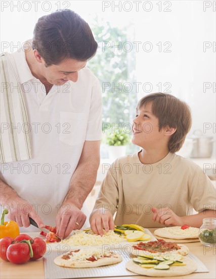 Father and son (10-11 years) preparing pizza. 
Photo : Daniel Grill