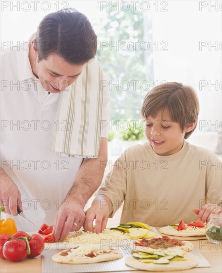 Father and son (10-11 years) preparing pizza. 
Photo: Daniel Grill