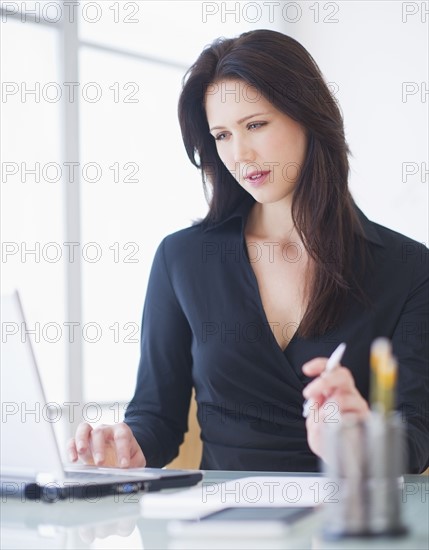 Businesswoman working at desk. 
Photo : Daniel Grill