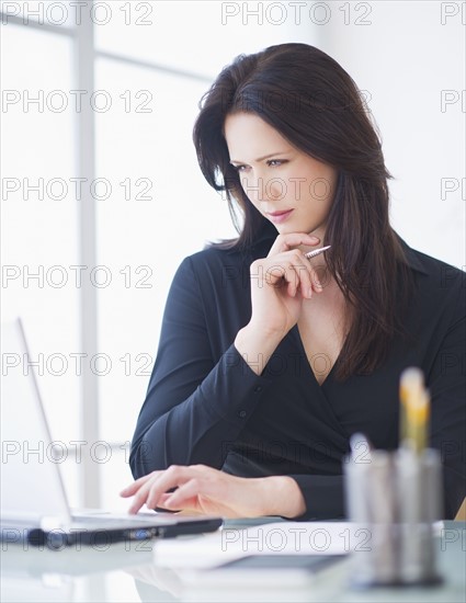 Businesswoman working at desk. 
Photo : Daniel Grill