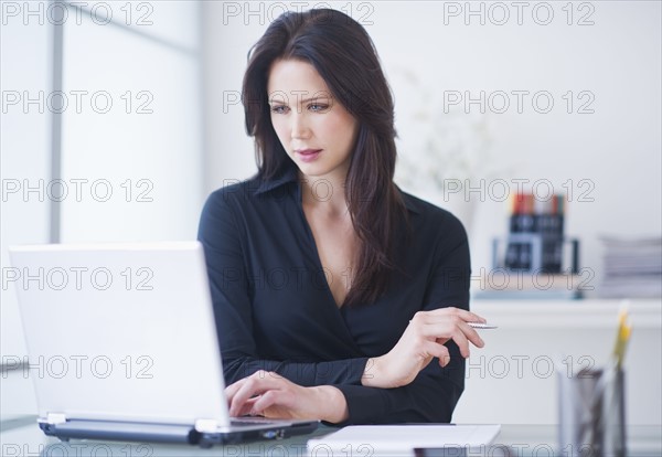 Businesswoman working at desk. 
Photo: Daniel Grill