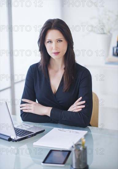 Portrait of businesswoman at desk. 
Photo : Daniel Grill