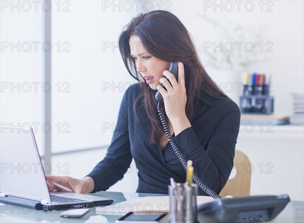 Businesswoman working at desk. 
Photo : Daniel Grill