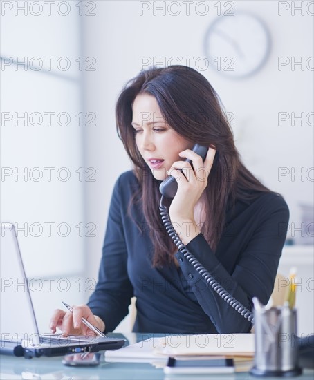 Businesswoman working at desk. 
Photo : Daniel Grill