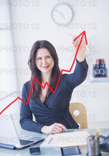 Businesswoman drawing graph. 
Photo : Daniel Grill