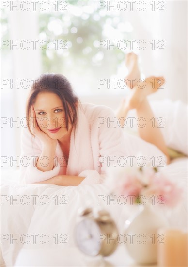 Portrait of young woman lying on bed. 
Photo: Daniel Grill