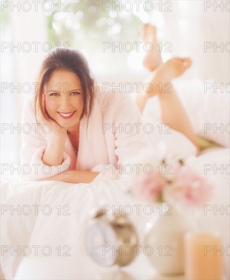 Portrait of young woman lying on bed. 
Photo : Daniel Grill
