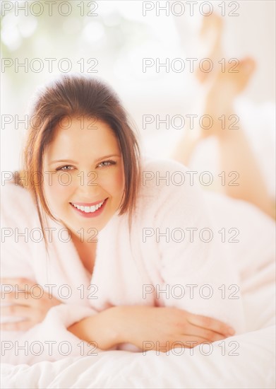 Portrait of young woman lying on bed. 
Photo: Daniel Grill