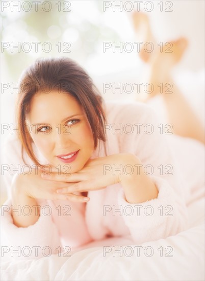 Portrait of young woman lying on bed. 
Photo : Daniel Grill