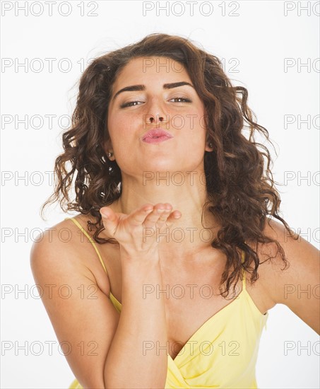 Portrait of young woman blowing kiss, studio shot. 
Photo : Daniel Grill