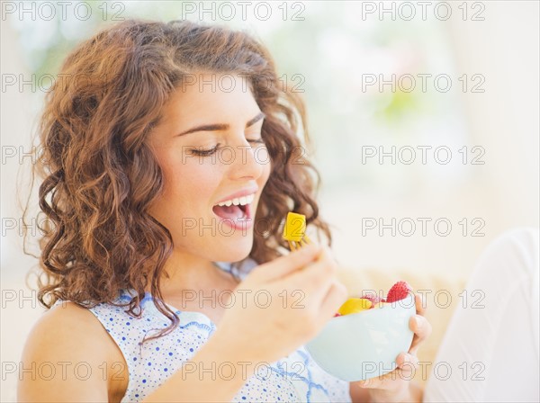 Portrait of woman eating fruit salad. 
Photo : Daniel Grill