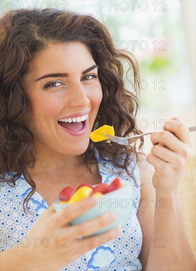 Portrait of woman eating fruit salad. 
Photo: Daniel Grill