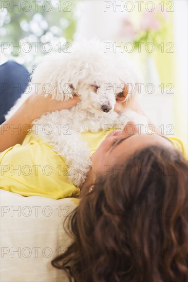 Woman lying on bed with her dog. 
Photo : Daniel Grill