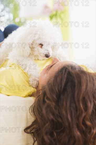 Woman lying on bed with her dog. 
Photo : Daniel Grill