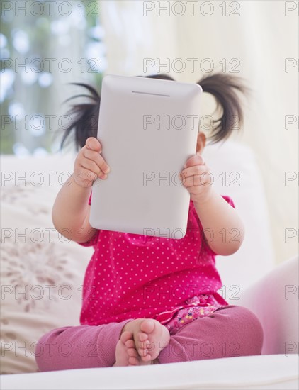 Baby girl (12-17 months) playing with digital tablet. 
Photo : Daniel Grill