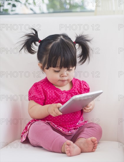 Baby girl (12-17 months) playing with digital tablet. 
Photo: Daniel Grill