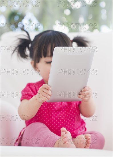 Baby girl (12-17 months) playing with digital tablet. 
Photo : Daniel Grill