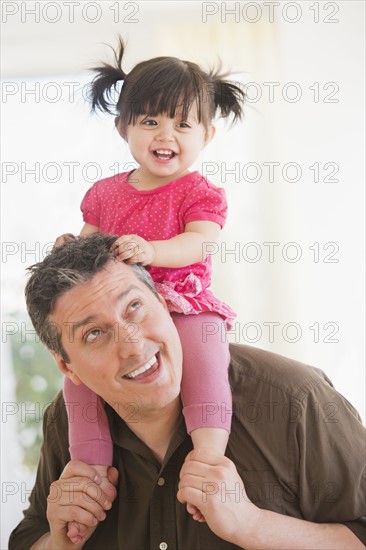 Father carrying baby daughter (12-17 months) on shoulders.
Photo : Daniel Grill
