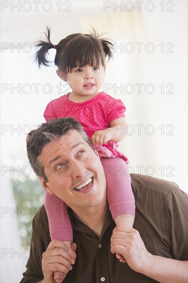 Father carrying baby daughter (12-17 months) on shoulders.
Photo : Daniel Grill