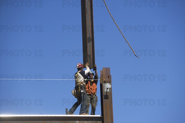 Construction workers on construction frame. 
Photo : fotog