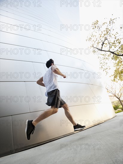 USA, California, Los Angeles, Young man running on city street.
