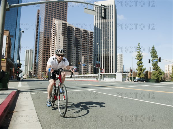 USA, California, Los Angeles, Young man road cycling on city street.
