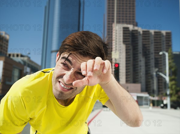 USA, California, Los Angeles, Young man resting after running on city street. 
Photo: Erik Isakson