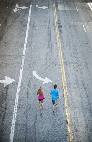 USA, California, Los Angeles, Elevated view of man and woman running on street.