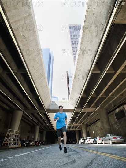 USA, California, Los Angeles, Young man running on city street.