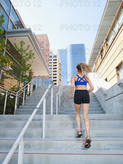 USA, California, Los Angeles, Young woman running on stairs.