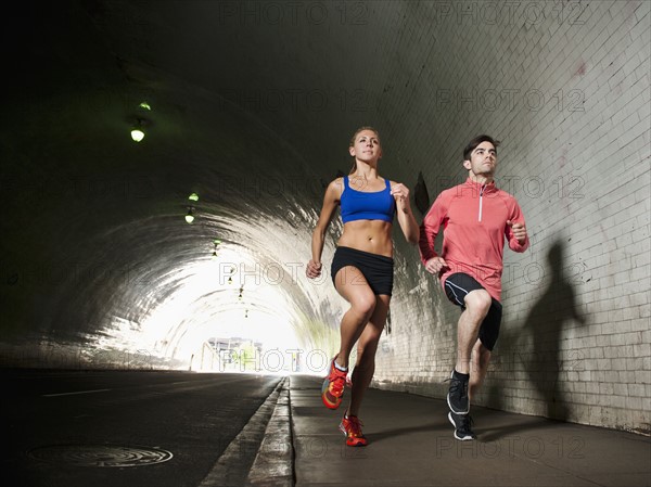 USA, California, Los Angeles, Young man and young woman running in tunnel. 
Photo: Erik Isakson