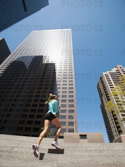 USA, California, Los Angeles, Young woman running on stairs.