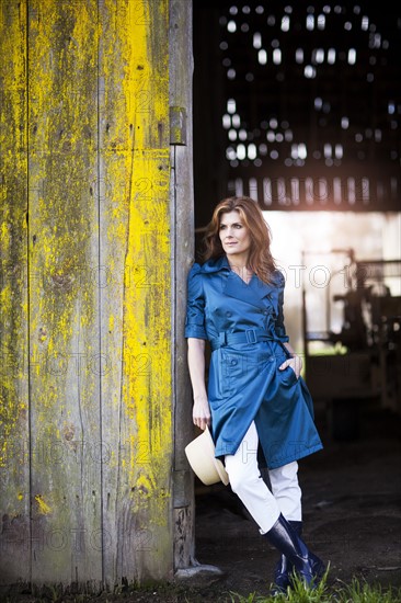 USA, Washington, Skagit Valley, Woman leaning on barn gate. 
Photo: Take A Pix Media