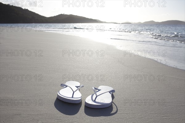 United States Virgin Islands, St. John, Pair of flip flops left on empty beach. 
Photo: Winslow Productions