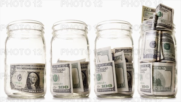 Glass jars filled with dollar bills. 
Photo: Mike Kemp