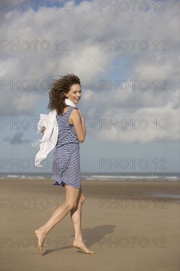 France, Pas-de-Calais, Escalles, Young woman strolling on empty beach. 
Photo : Jan Scherders