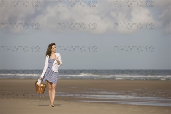 France, Pas-de-Calais, Escalles, Young woman strolling on empty beach. 
Photo : Jan Scherders