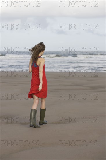 France, Pas-de-Calais, Escalles, Young woman strolling on empty beach. 
Photo : Jan Scherders