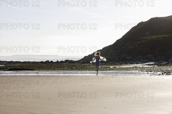 France, Pas-de-Calais, Escalles, Young woman strolling on empty beach. 
Photo : Jan Scherders