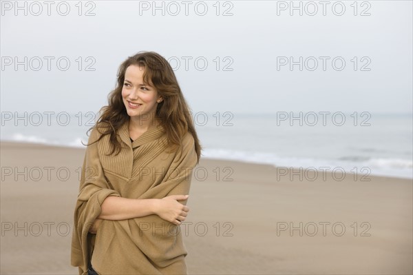 Young woman strolling on empty beach. 
Photo: Jan Scherders