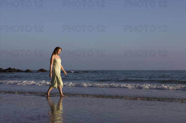 France, Pas-de-Calais, Escalles, Young woman strolling on empty beach. 
Photo : Jan Scherders