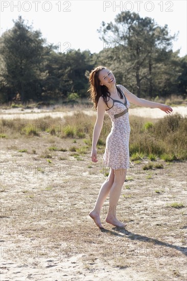 Belgium, Kalmthoutse Heide, Young woman walking barefoot. 
Photo: Jan Scherders