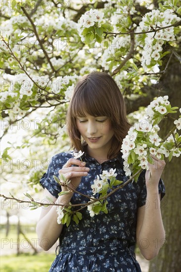 Portrait of young woman in blooming orchard. 
Photo: Jan Scherders