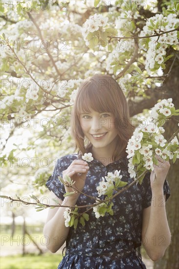 Portrait of young woman in blooming orchard. 
Photo : Jan Scherders