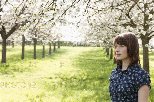 Belgium, Sint-Truiden, Portrait of young woman in spring orchard. 
Photo : Jan Scherders