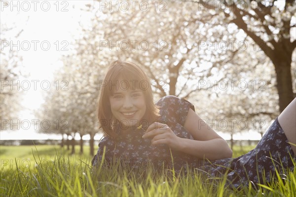 Belgium, Sint-Truiden, Portrait of young woman in spring orchard. 
Photo : Jan Scherders