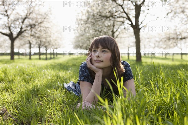 Belgium, Sint-Truiden, Portrait of young woman in spring orchard. 
Photo: Jan Scherders